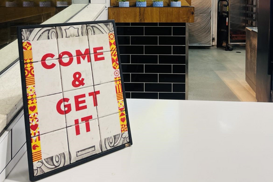 Sign in a food court that reads "come and get it"